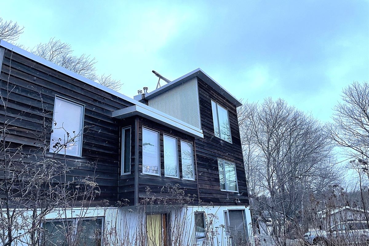 Bold architectural exterior of The Crag in the heart of Otter Creek village. Located just steps from the iconic Acadia Hot Showers and local general store, this modern retreat serves as your private backdoor entrance to Acadia National Park.