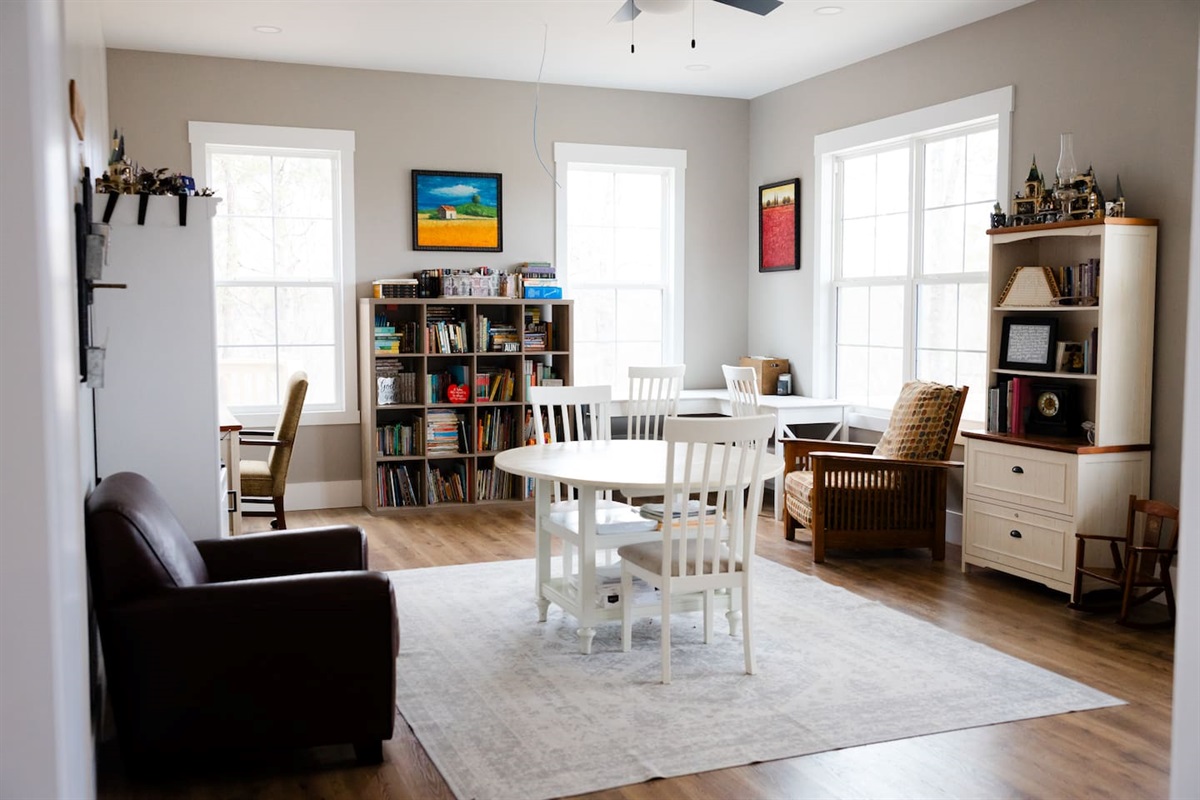 Our library features three work spaces, two comfy chairs for reading, PLENTY of books (we love the classics!), children's art supplies & crafts, as well as a piano and a few guitars. Beautiful views from these windows too. Open to living room/foyer.