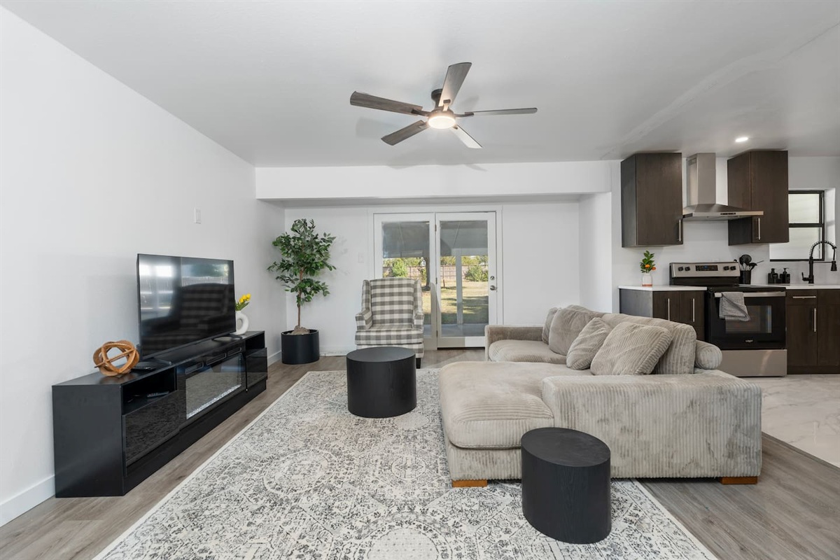 Bright and inviting living room featuring a plush sofa, Smart TV with Netflix and Roku, and access to the covered porch. Perfect for cozy nights in or streaming your favorite shows after exploring Grand Prairie.
