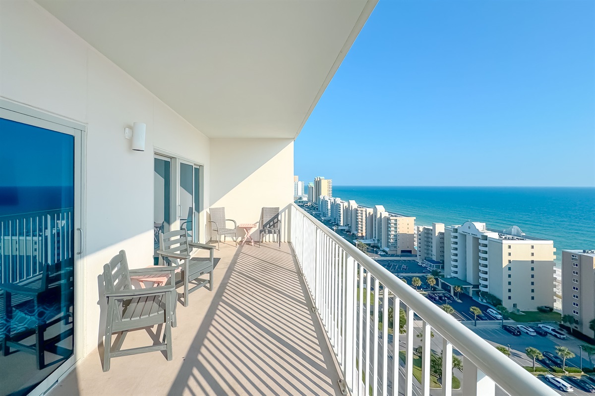Gain a new perspective on coastal beauty with this panoramic view.  Witness the vastness of the beach and the shimmering sea.