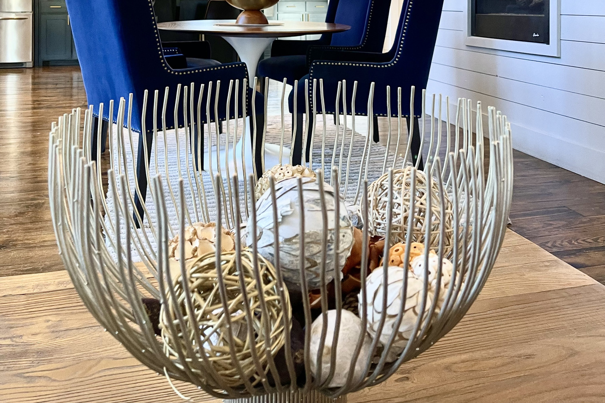 Sitting on the relaxing sofa in the living room, looking over the fun coffee table centerpiece towards the dining area and the kitchen beyond.