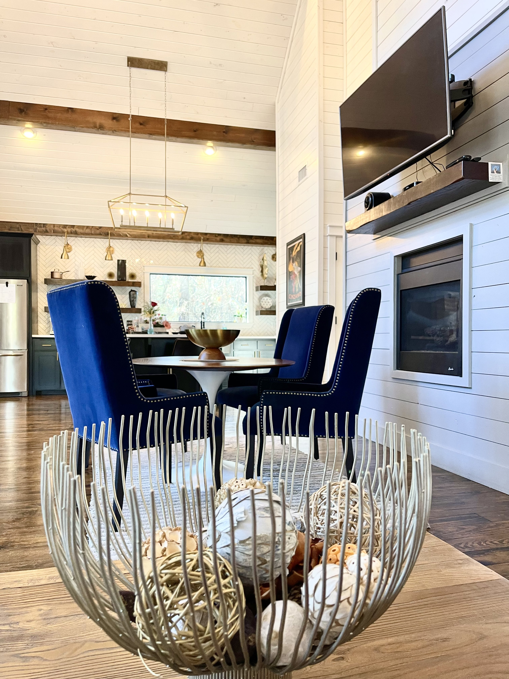 Sitting on the relaxing sofa in the living room, looking over the fun coffee table centerpiece towards the dining area and the kitchen beyond.