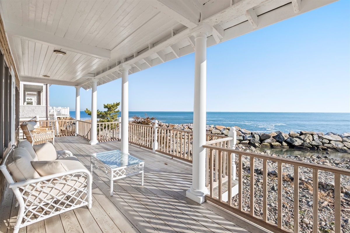 Oceanfront porch with comfortable seating, perfect for relaxing while enjoying unobstructed views of the water and the soothing sound of the waves. 🌊☀️