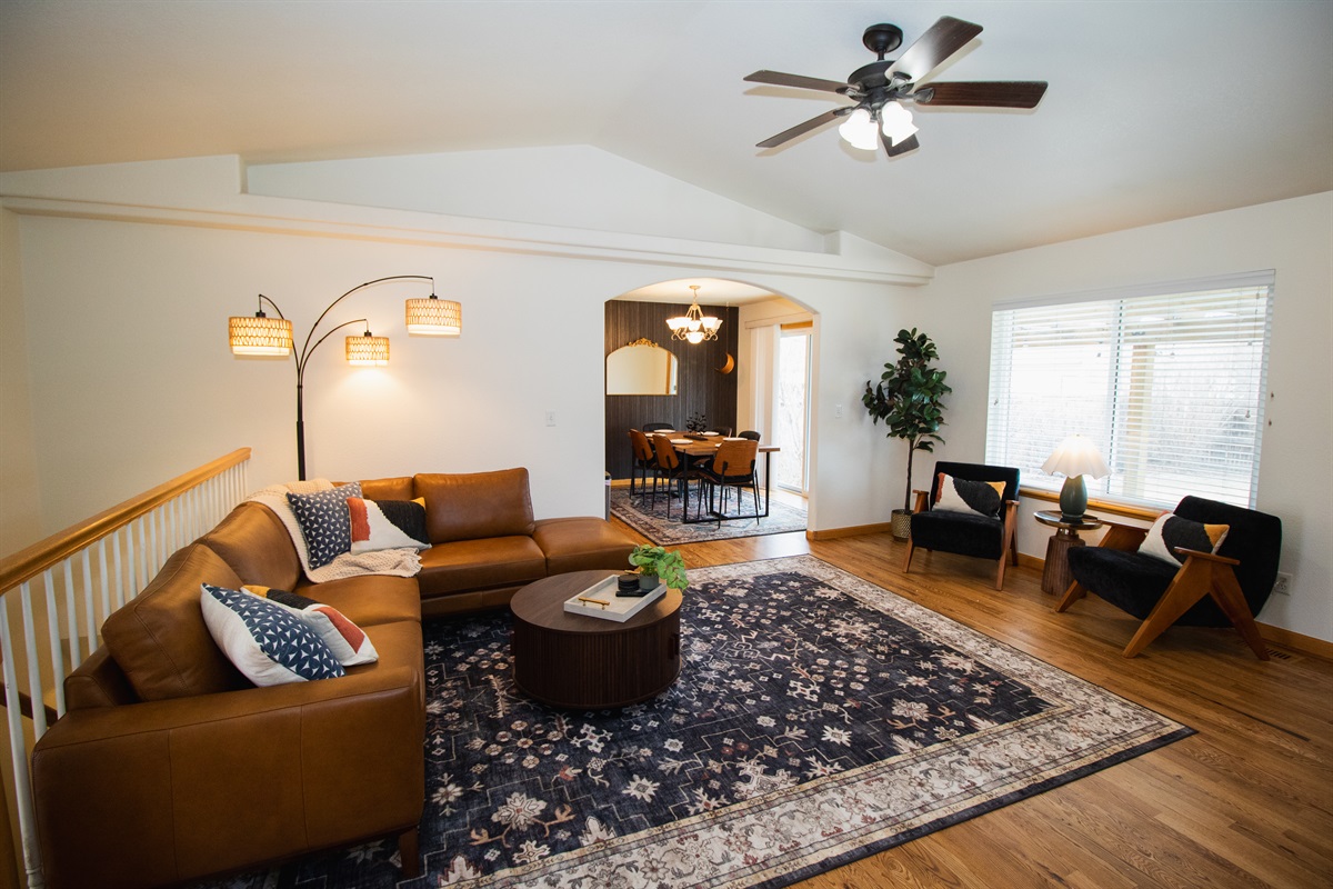 Enjoy a spacious and warm living area with high-ceilings, moody finishes, smart tv, and comfortable seating