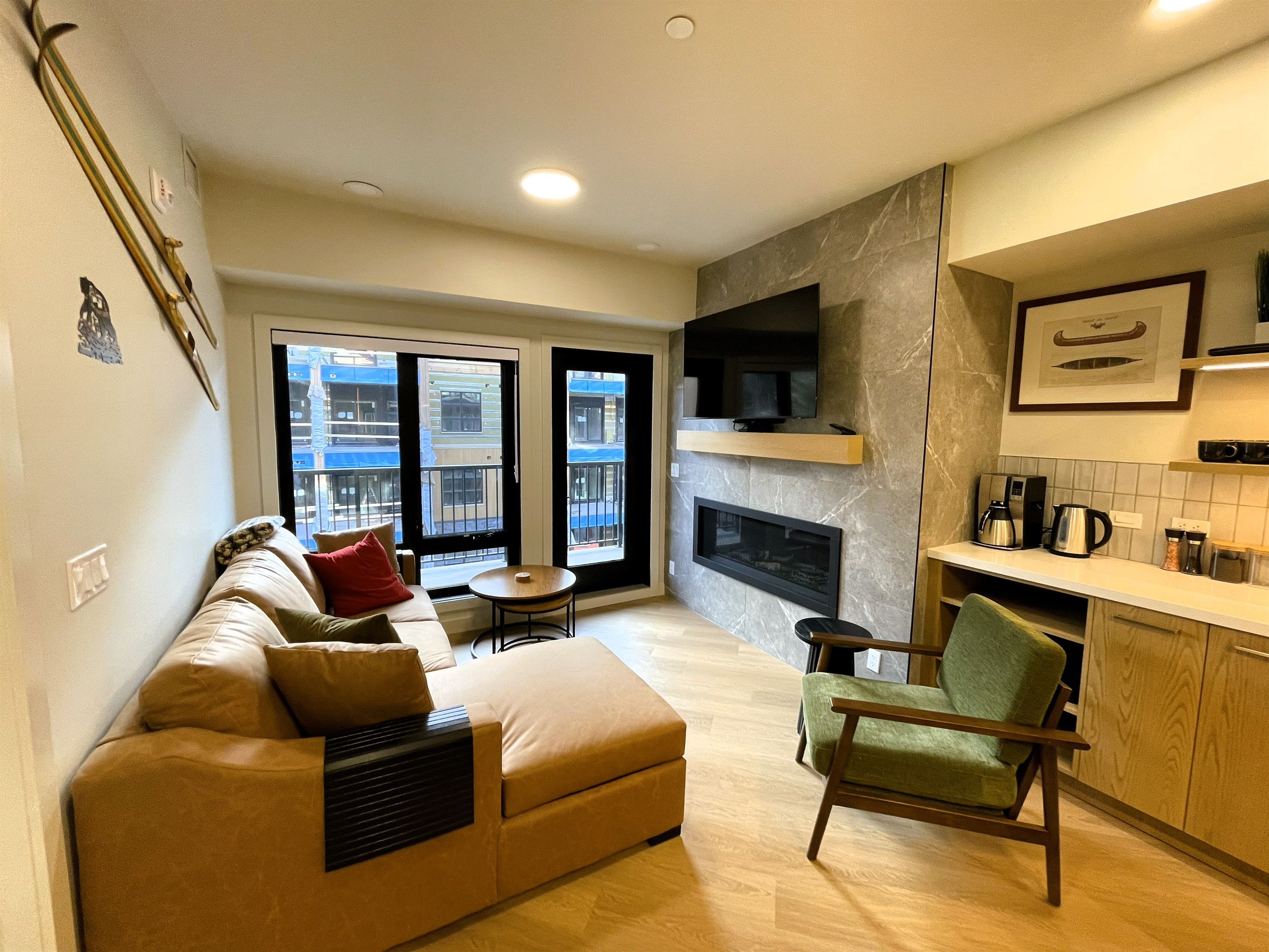 Living room with a leather sofa, gas fireplace, 55" TV, spacious balcony, it is open to adjacent kitchen area. The large sofa fold out queen sofa bed, linens are provided. Mountain decor compliments the room. 