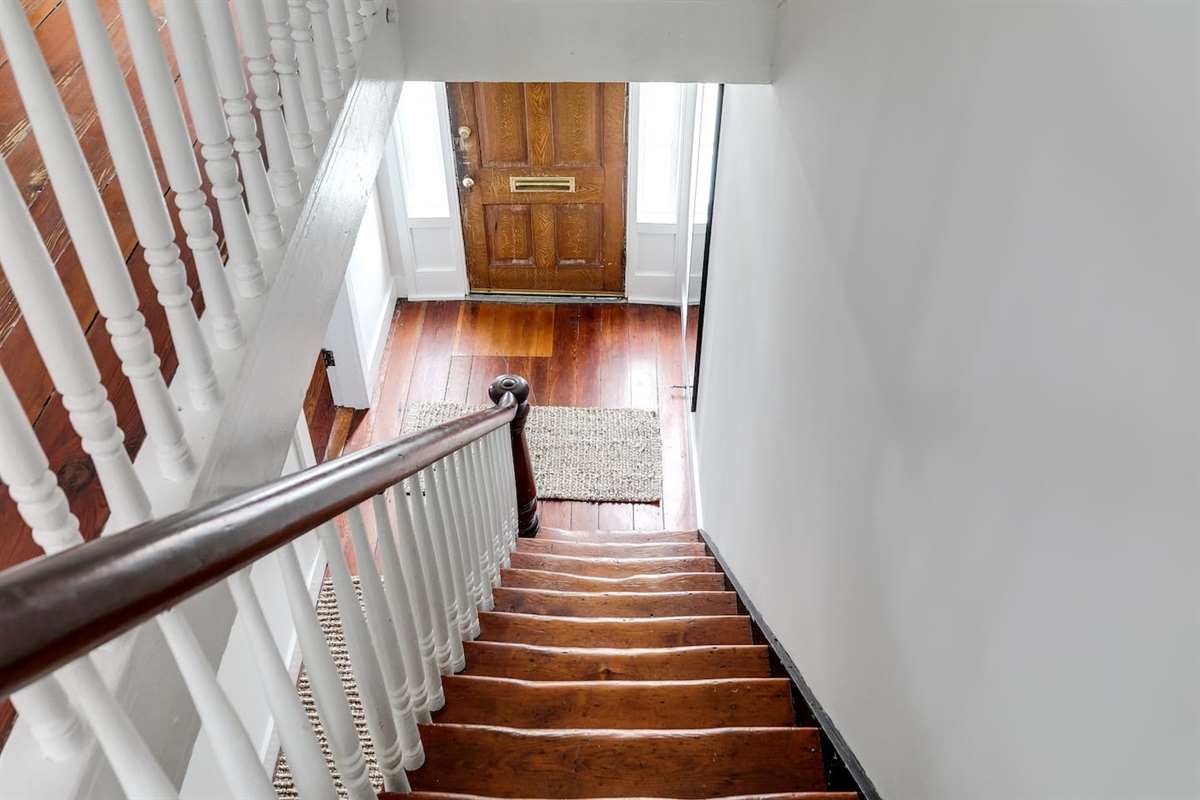 Step into charm with natural light, rich wood floors, and classic stairway elegance!