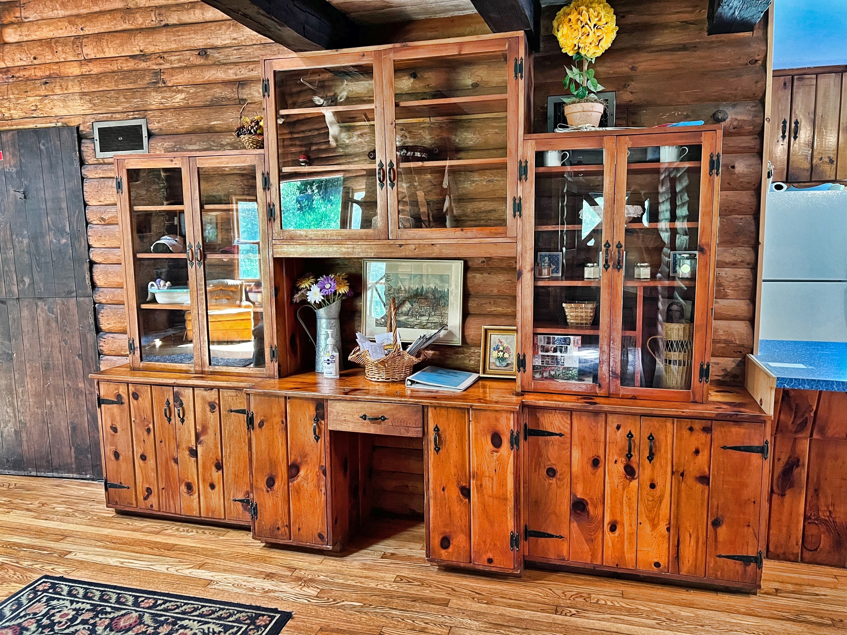 Knotty Pine built-in cabinetry with board games and area information. Located in between the living room and kitchen.
