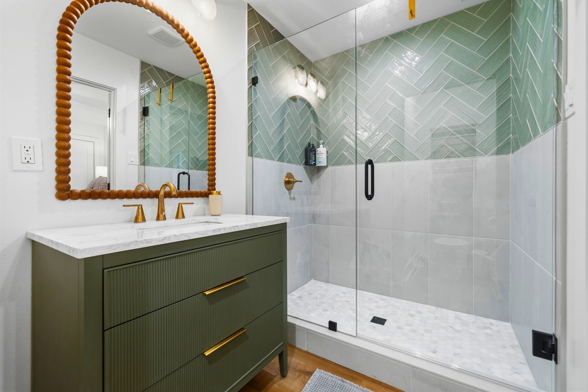 Eye-catching tile work and a spacious shower create a refreshing and comfortable bathroom space.