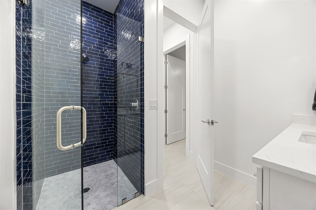 Step into this stylish bathroom featuring a beautiful shower enclosed with a sleek glass cover, complemented by an elegant tile design that enhances its modern charm.