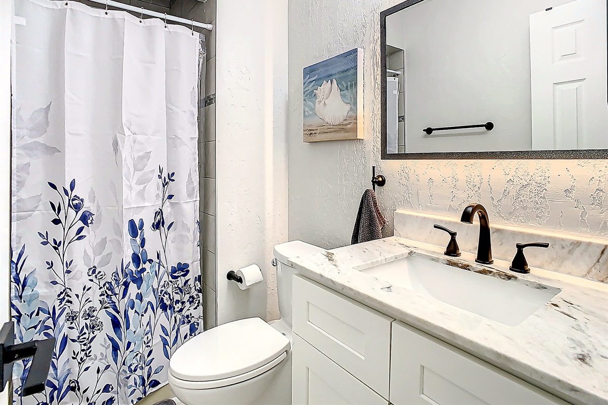 Elegant bathroom featuring modern vanity with sink, large mirror, and neutral color scheme for a spa-like experience.