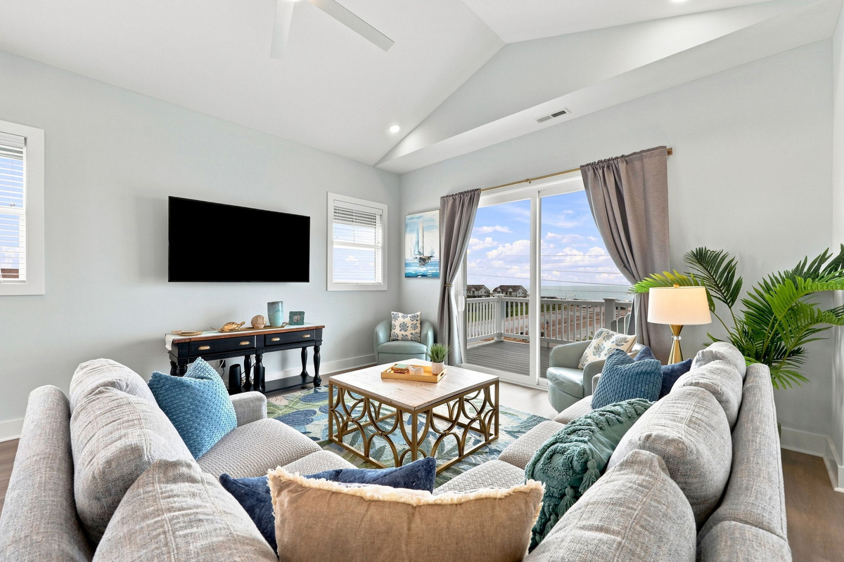Relax and reconnect in the spacious living area featuring comfortable seating, coastal d&eacute;cor, and plenty of room to gather after a day by the shore