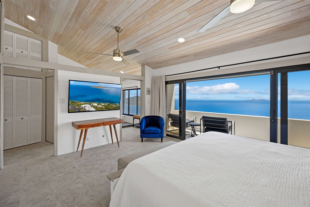 Primary bedroom with king bed, Smart TV, balcony, ceiling fan and ensuite bathroom