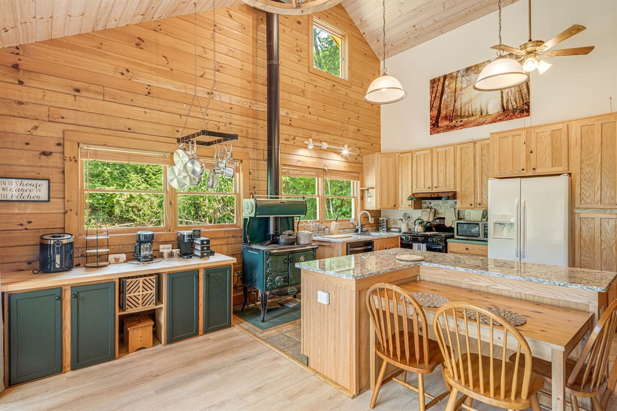 Start your day in this charming mountain kitchen, where rustic wood tones and natural light create a warm, inviting space with an abundance of cookware and dinner wear.