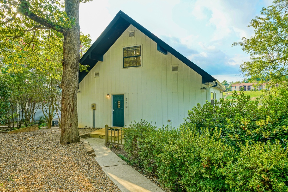 Tucked away in lush greenery, the private entrance offers a warm welcome to your modern lakefront escape.