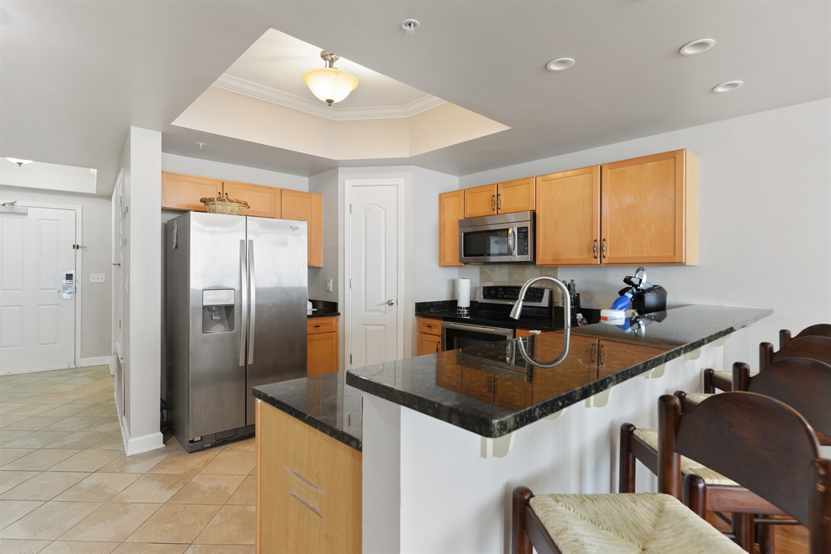 Full kitchen with all appliances, looking at front door and hallway.
