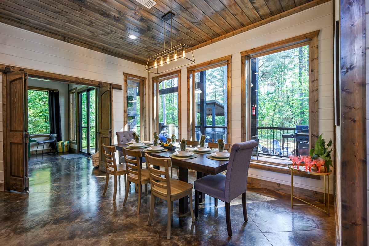 Cozy dining nook surrounded by nature-filled windows