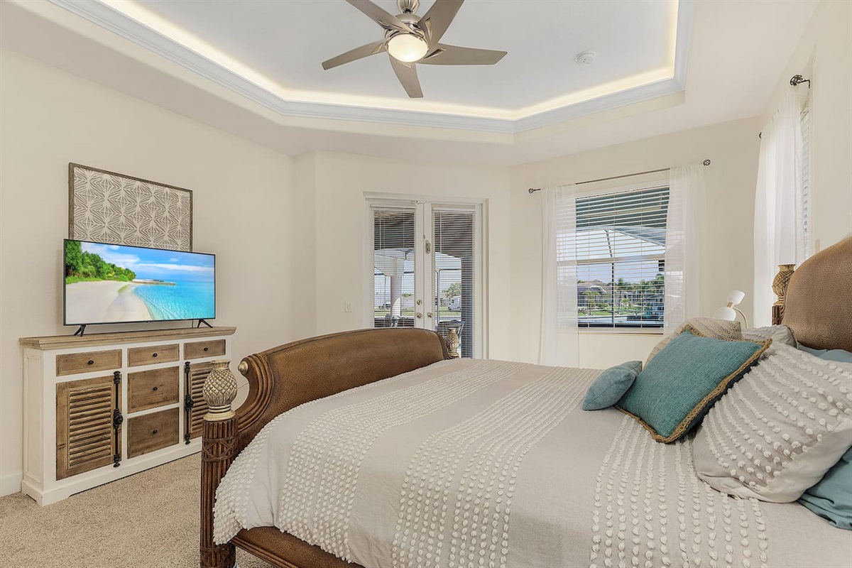 Primary suite (King-size) with Smart TV and direct access to pool and lanai area.