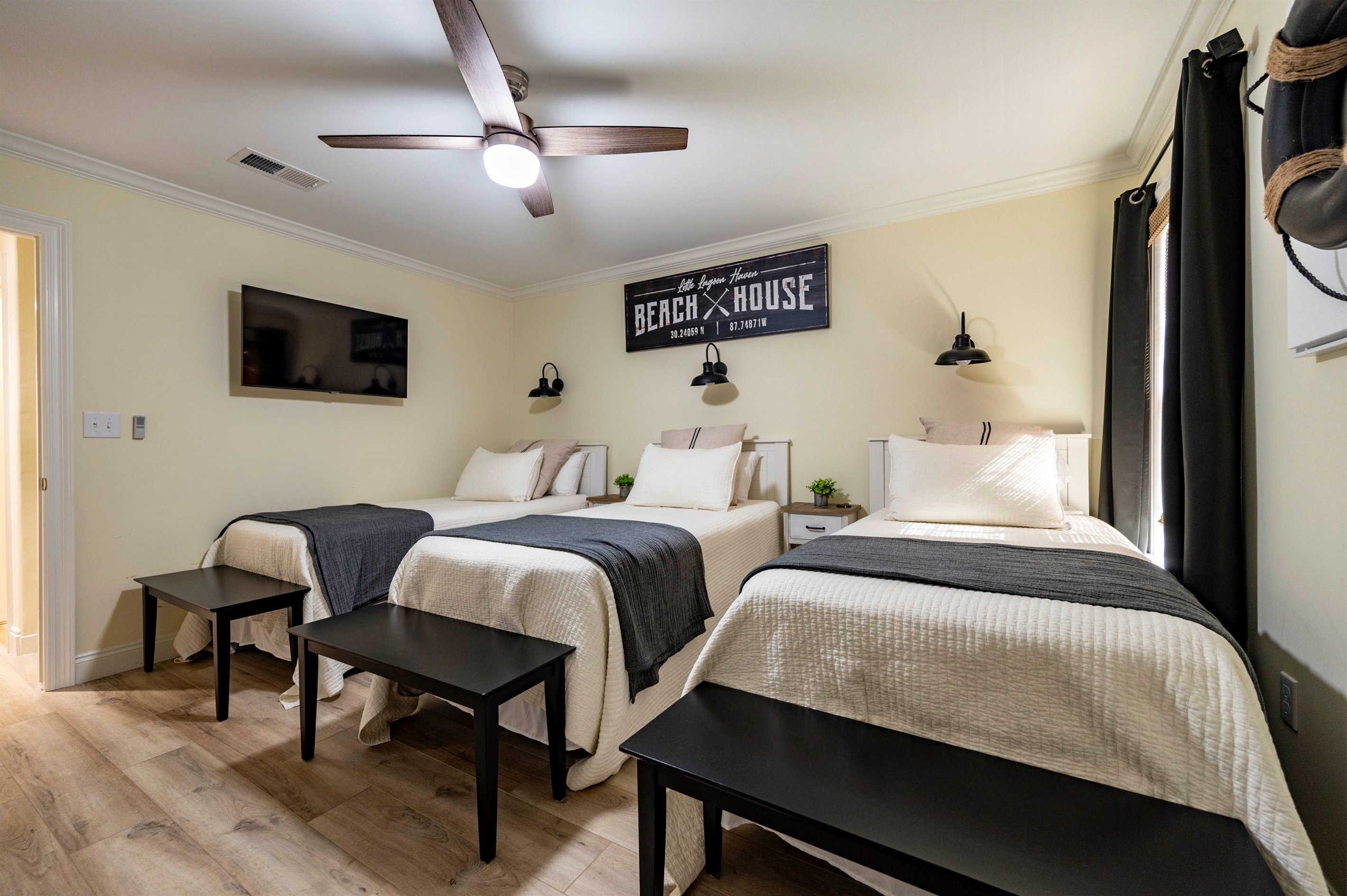 Cozy beach house bedroom with three beds, nautical decor, and relaxing vibes.