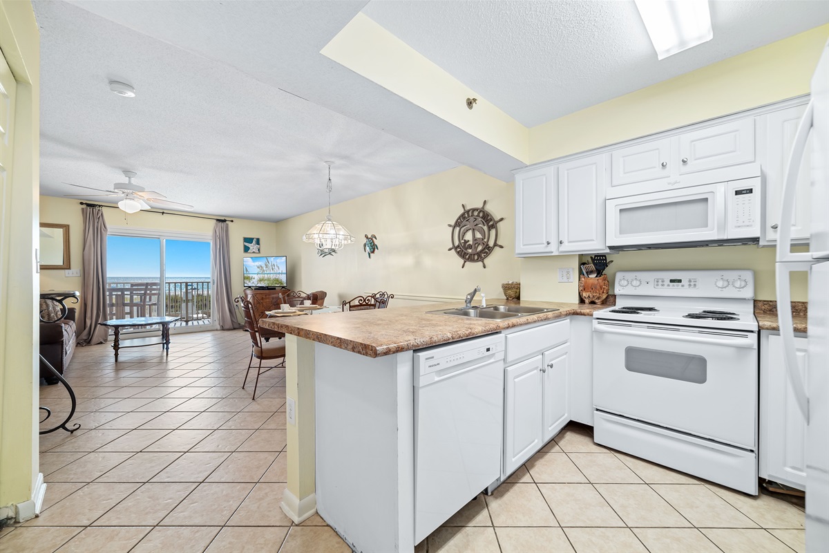 This fully functional kitchen boasts stainless steel appliances, sleek countertops, stunning ocean views, and ample cabinet storage, ideal for everyday cooking and entertaining while on vacation.