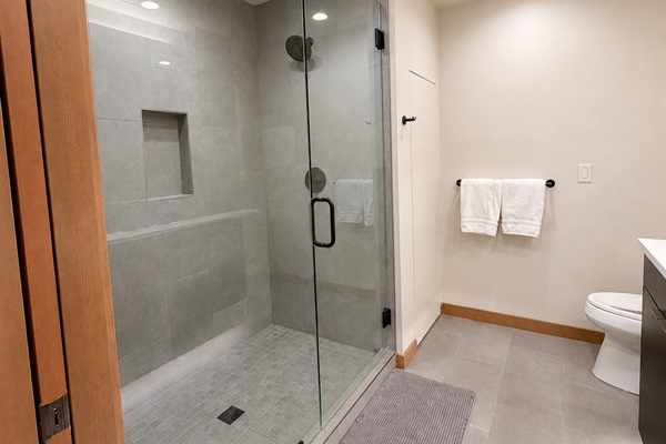 Spacious glass-enclosed walk-in shower.