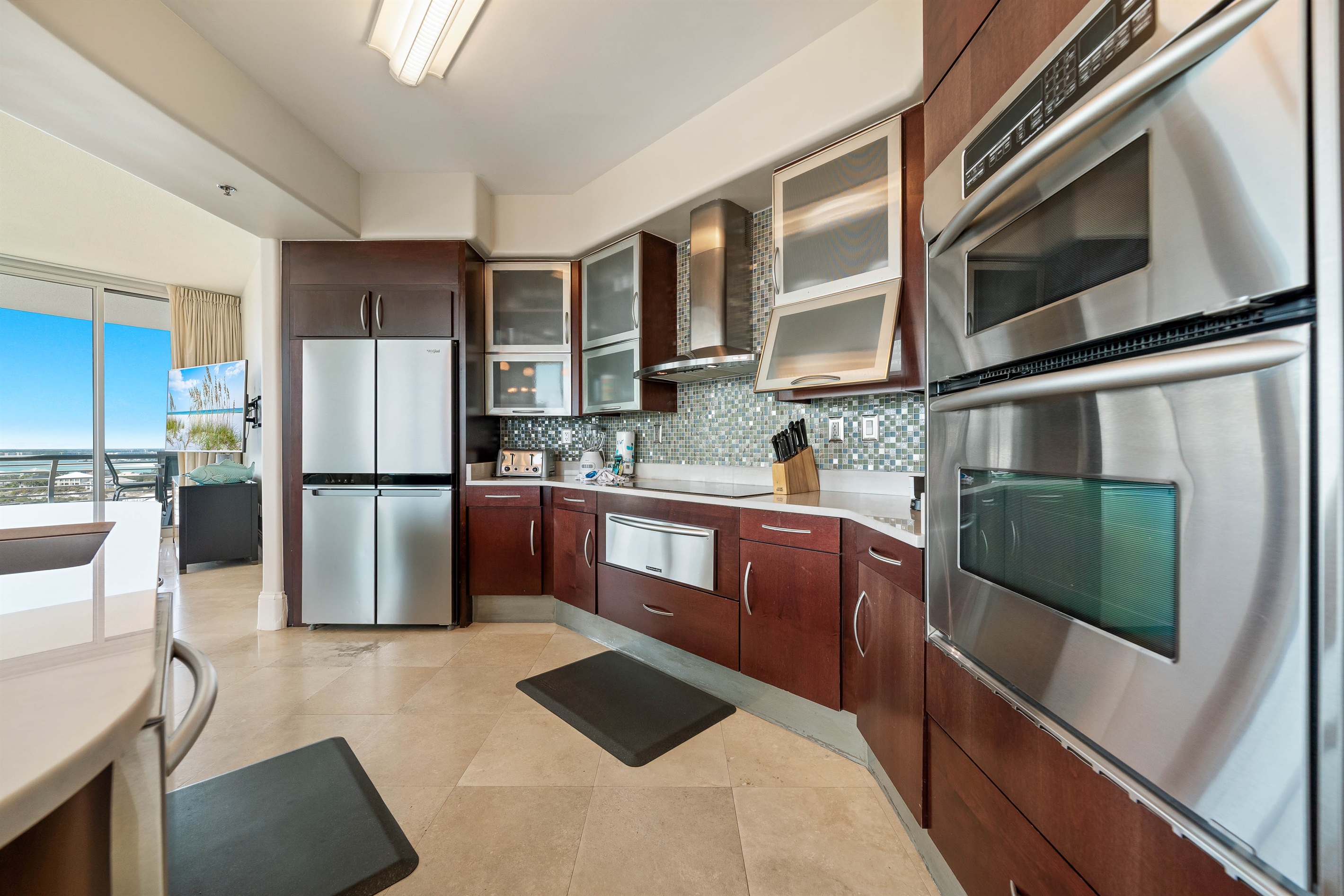 This gourmet kitchen, featuring stainless steel appliances and granite countertops, seamlessly flows into the spacious living area, perfect for entertaining and enjoying breathtaking views.