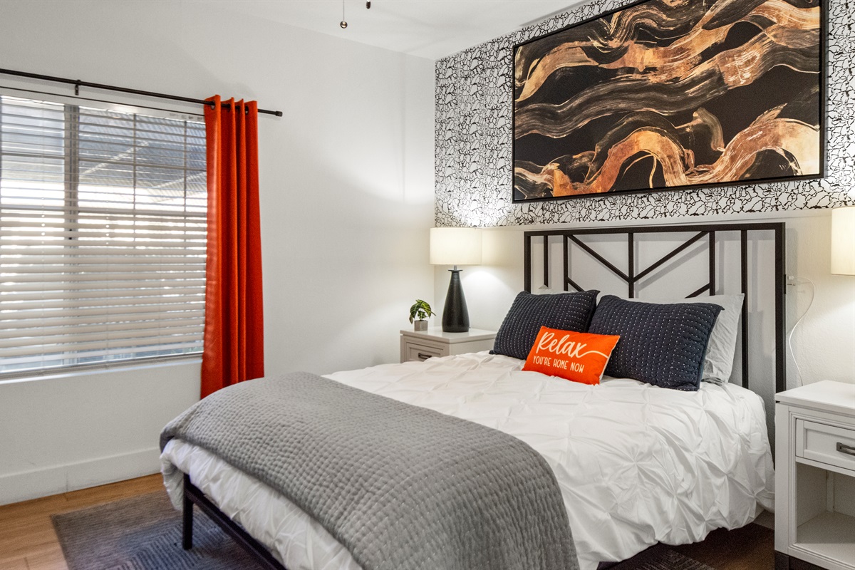 A bedroom that offers a calm and inviting atmosphere with modern furnishings, warm lighting, and tasteful décor that creates a true home-away-from-home experience