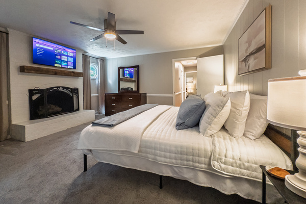 King bed, 55" Smart TV, ceiling fan, two led light nightstands with multiple charging ports, two multi light function lamps, blackout curtains, dresser, wardrobe closet, full length mirror, stylish brick fireplace - not in use.