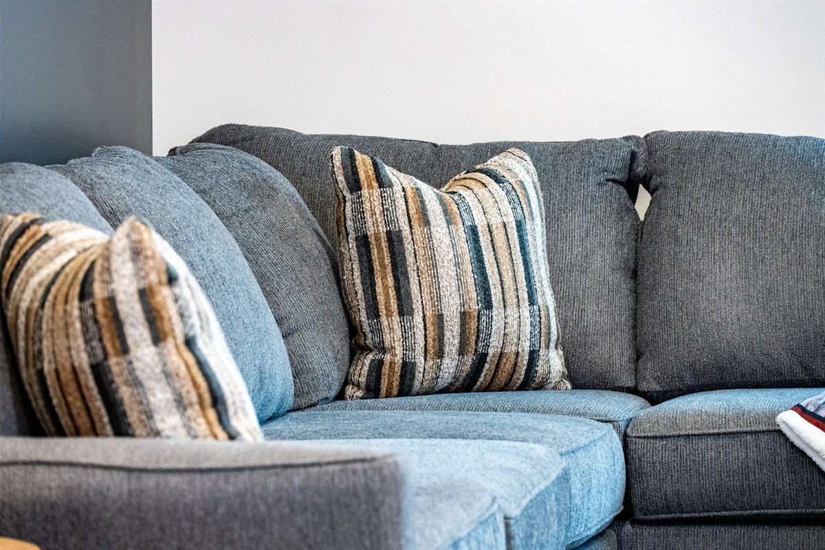 Comfortable living room seating with soft, textured pillows for a relaxing stay.