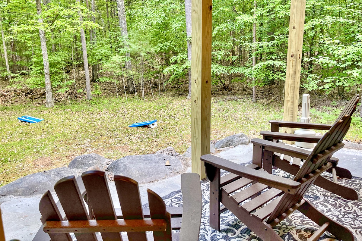 Oversee a game of cornhole from the back patio at Adirondack Mountain Cabin.