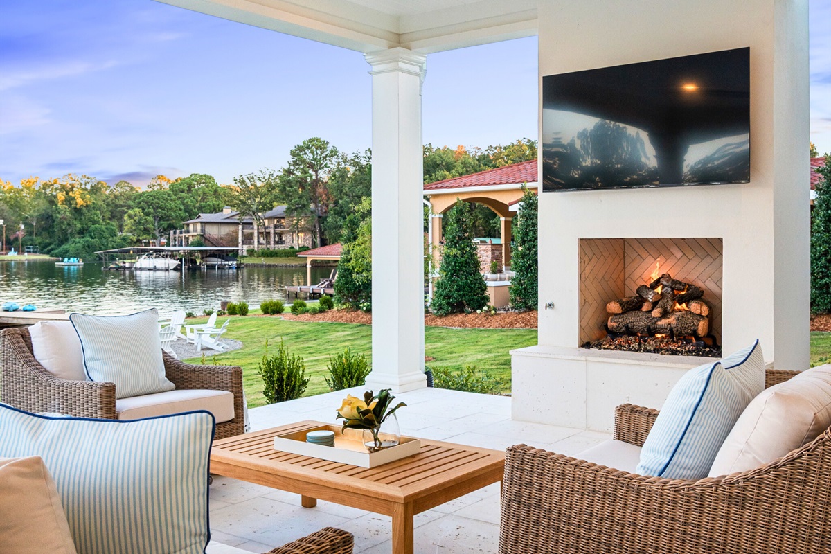 Covered porch with cozy seating and views of manicured grounds.