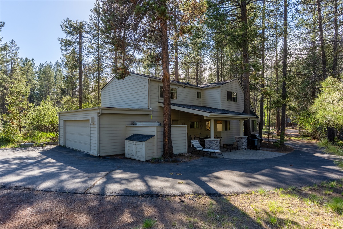 An expansive driveway welcomes you in, leading to a covered outdoor seating area perfect for relaxing, along with a gas grill and private hot tub for the ultimate Sunriver experience.