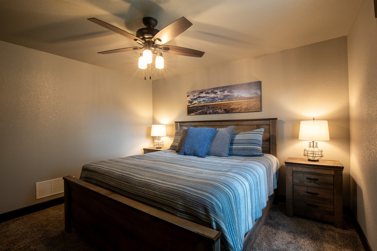 This large and inviting king bedroom offers warm lighting, cozy bedding, and easy access—perfect for relaxing after a day of adventure.