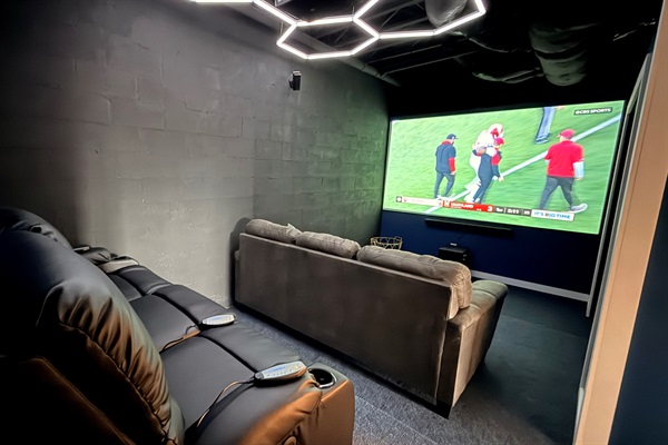 A premium theater room offering reclining, heated, massaging leather seating, a cinematic projection system, and rich acoustics for an elevated, private movie-theater experience during your stay.