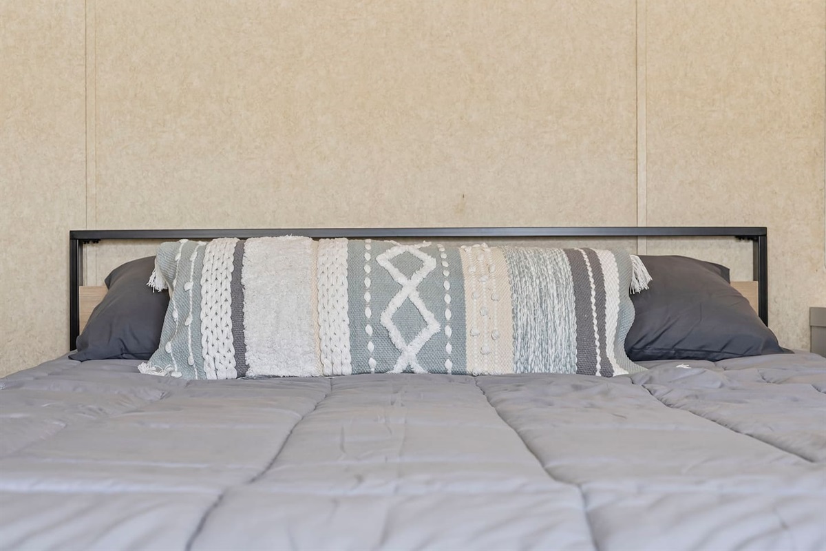 Detailed view of cozy bedding and bedside setup, creating a warm and inviting atmosphere.