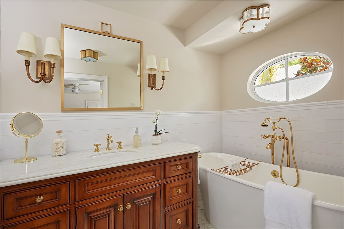 The primary bath features elegant lighting and plush, fluffy towels for a spa-like experience.