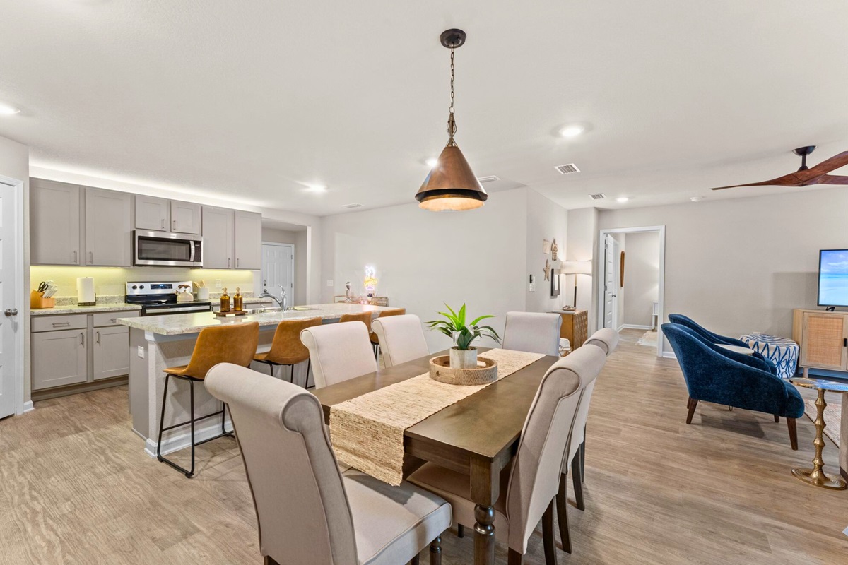 An open view of the dining and living spaces makes the home feel connected, bright, and welcoming.
