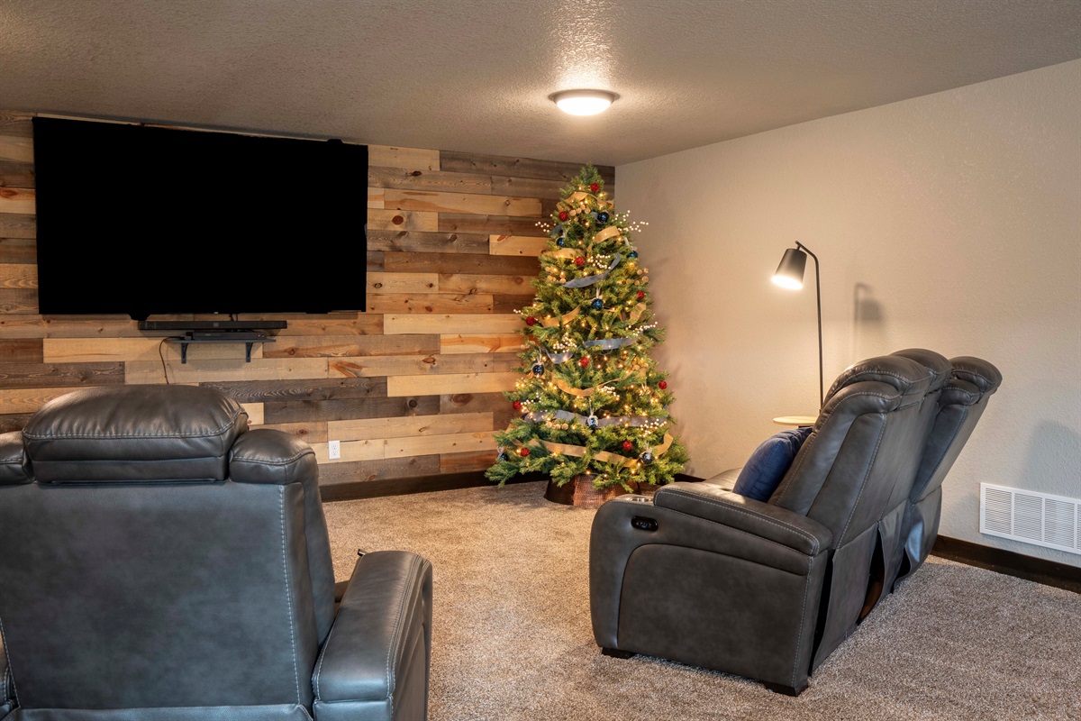 Festive lounge ready for your holiday stay—complete with cozy recliners, soft lighting, and a beautifully lit Christmas tree. The perfect spot for family movies, relaxing together, and opening gifts on Christmas morning.