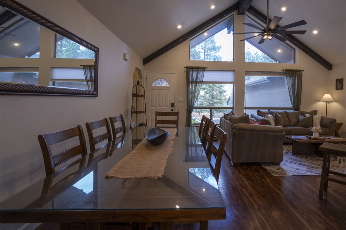 Dining and living area with high ceilings, wood floors, and a comfortable layout for gathering.