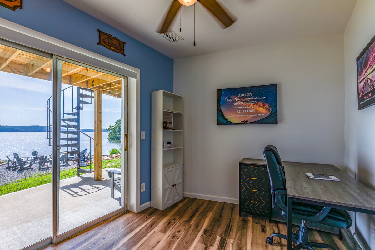 The dedicated workspace offers a desk, chair, Wi-Fi, and sliding-door access toward the lakefront patio.
