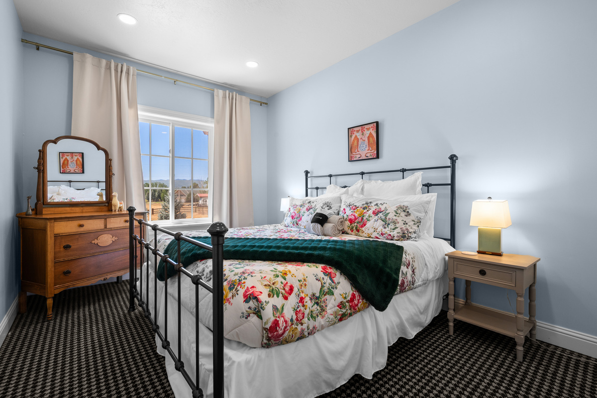 A charming queen bedroom with recessed lighting, and thoughtful decor designed for a peaceful night’s rest.