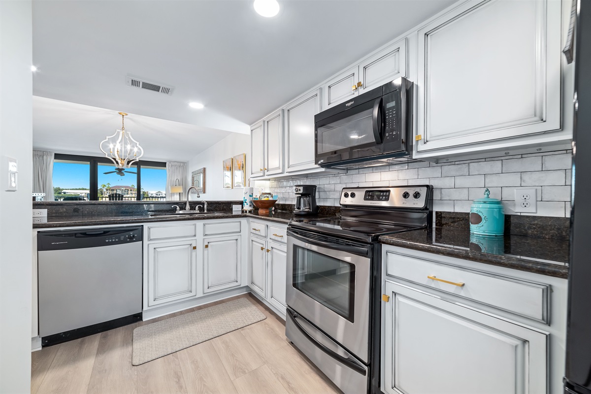 This fully functional kitchen boasts stainless steel appliances, sleek countertops, a decorative backsplash, and ample cabinet storage, ideal for everyday cooking and entertaining.