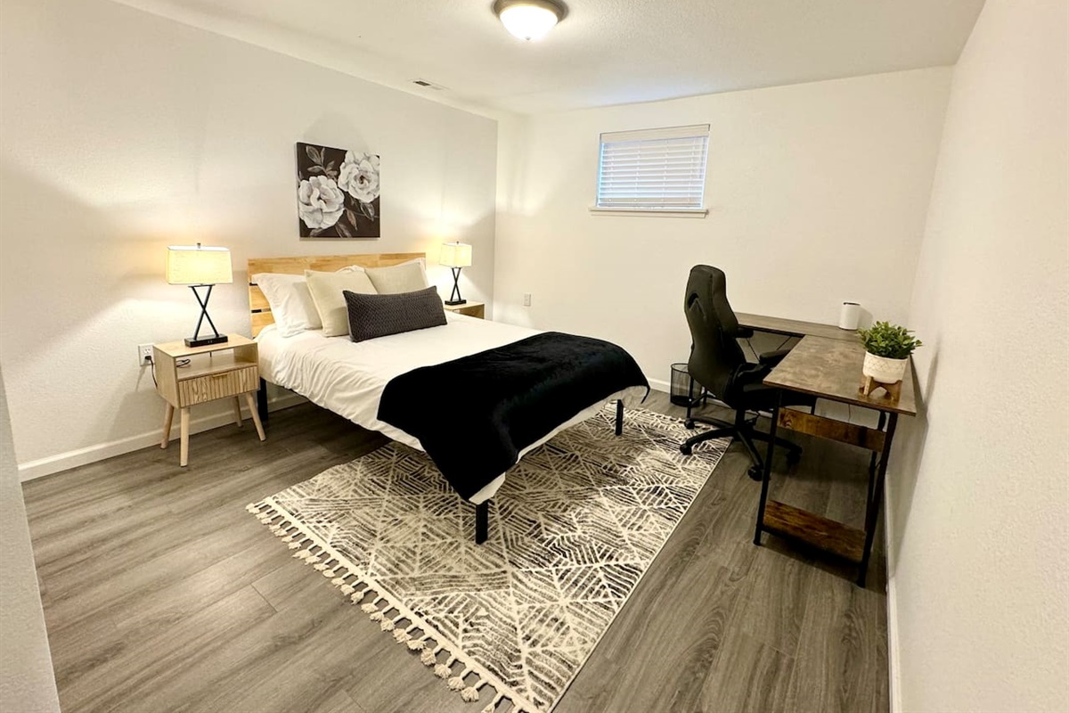 Basement bedroom with double bed and desk