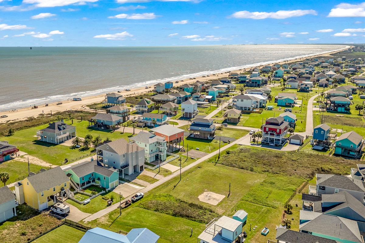 Costa Cristal Exterior: Aerial view of the beautiful coastal neighborhood with spacious homes, open skies, and easy access to the shore.