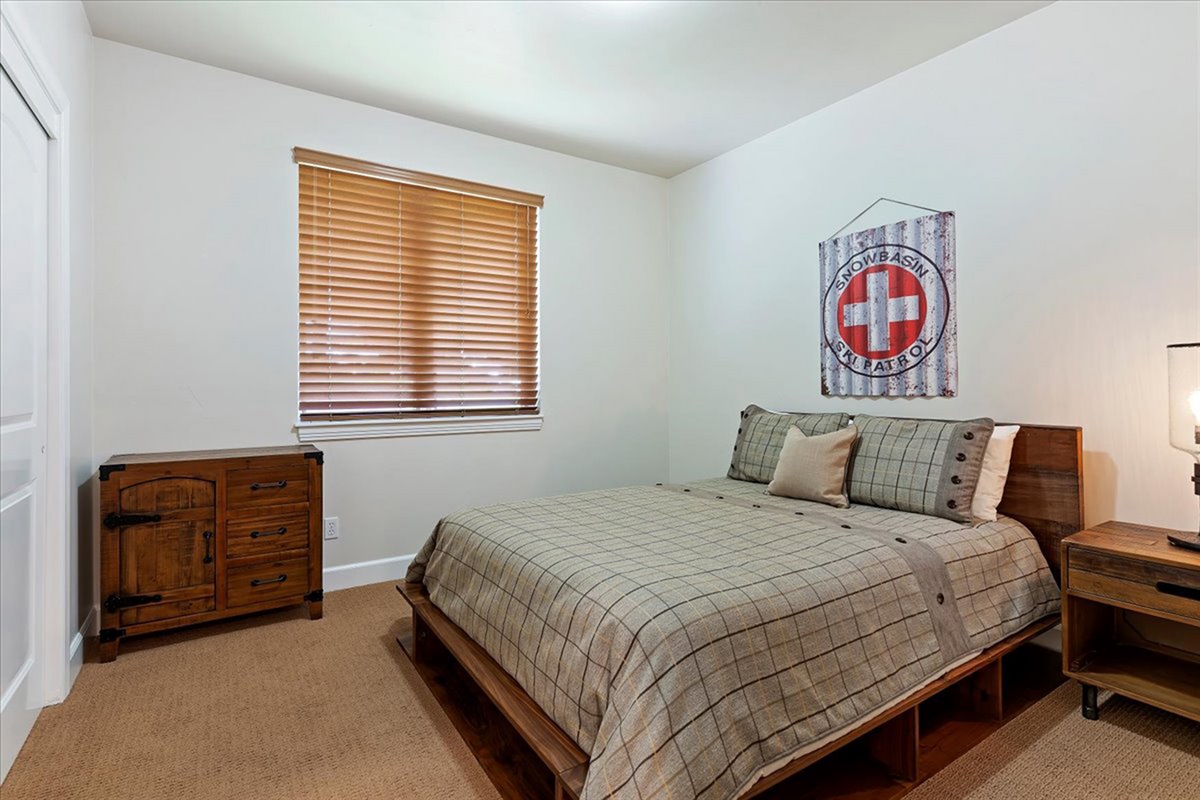 A comfortable guest bedroom with a cozy queen bed, warm finishes, and a peaceful atmosphere for a restful night.