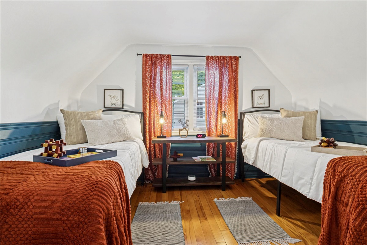 Twin XL beds with white noise machine, bedside chargers, alarm clock, and wall-mounted TV offer restful sleep. A safety rail and step stool add peace of mind at our South Bend guest retreat.