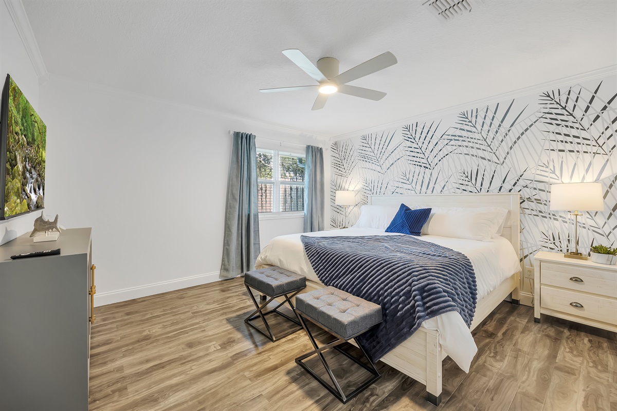 Stylish primary suite with bold accent wall and plush bedding