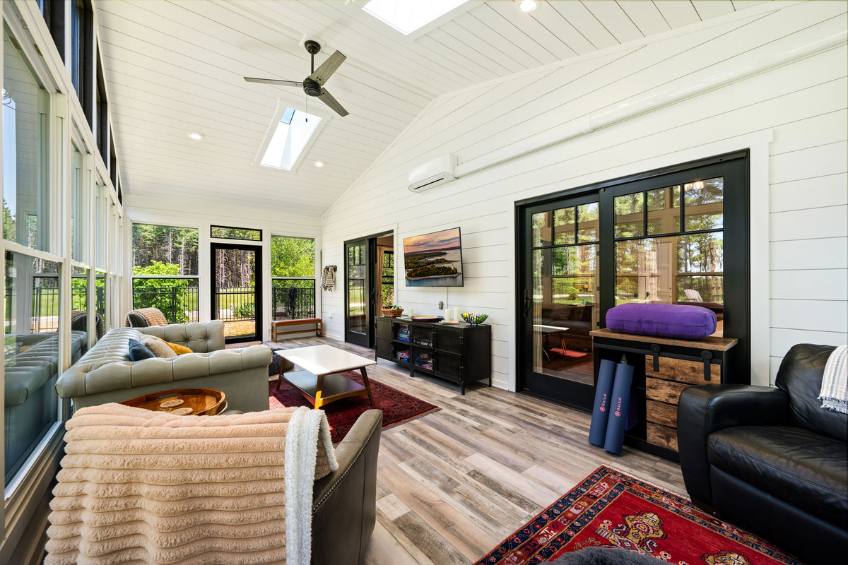 Stretch, stream, or simply relax in the versatile sunroom, complete with yoga mats and bolster, a smart-TV, and sweeping forest views.