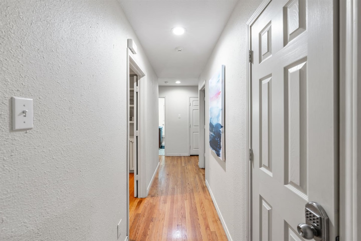 Bright, inviting hallway with sleek flooring and soft lighting connecting bedrooms and living areas.