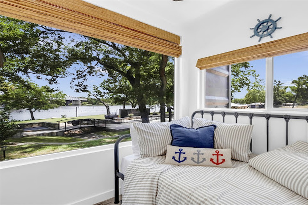 Cozy daybed with tranquil river and tree-lined views.