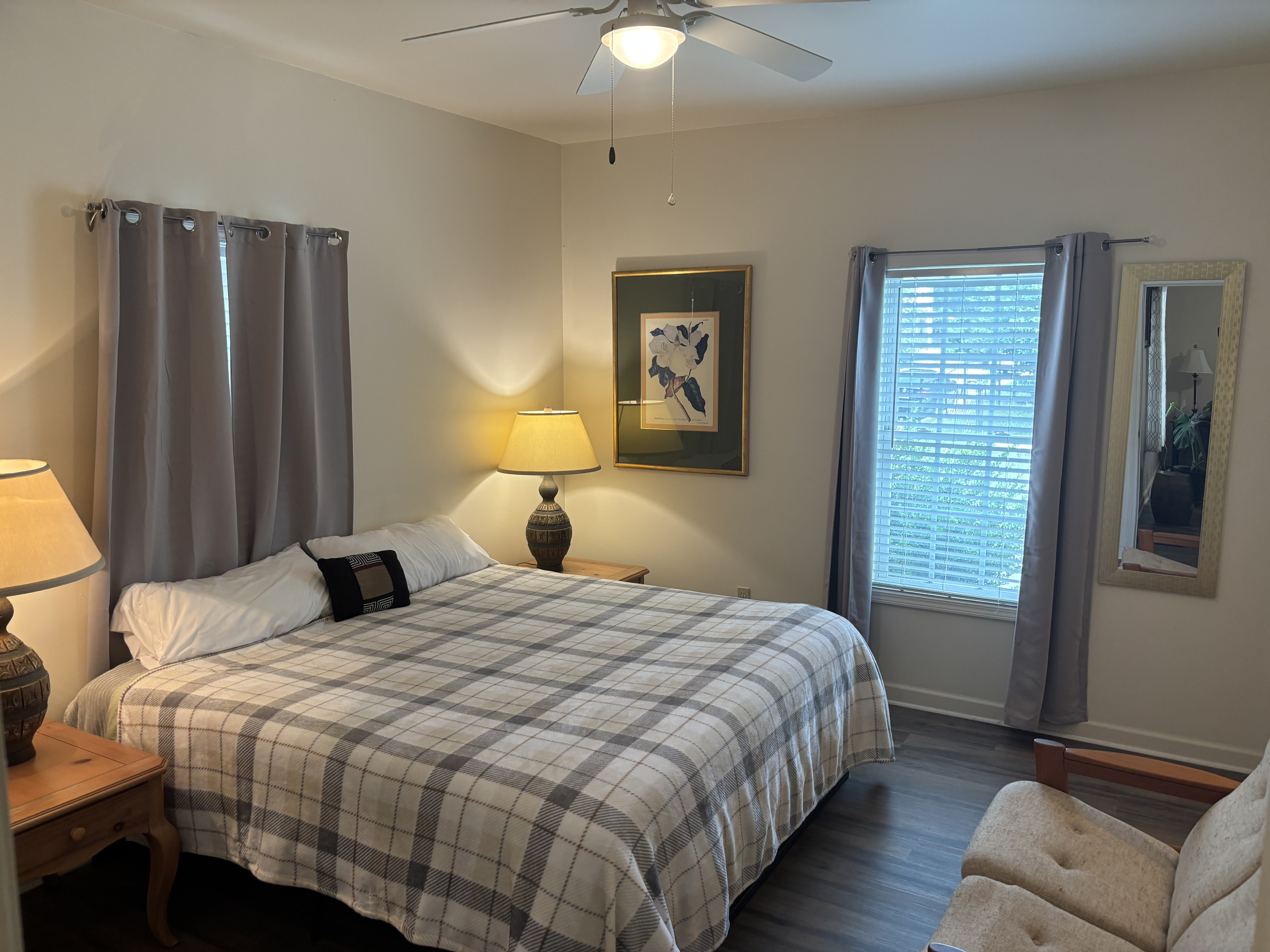 Spacious primary suite with a king bed, blackout curtains, comfortable sitting area and private en-suite bathroom.